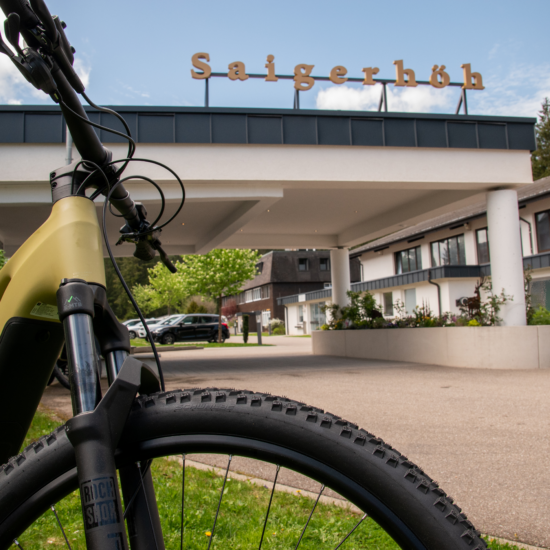 E-Mountainbike vor dem Eingangsbereich des Hotel Saigerhöh in Saig – idealer Ausgangspunkt für abwechslungsreiche Radtouren und Mountainbike-Abenteuer im Hochschwarzwald.